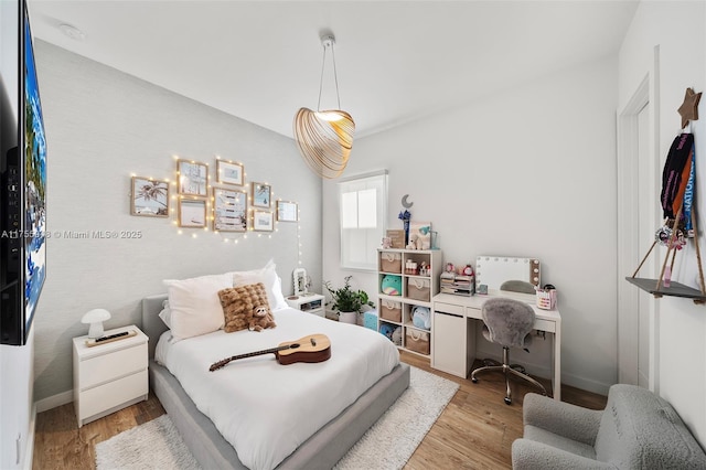 bedroom featuring light wood-style flooring and baseboards