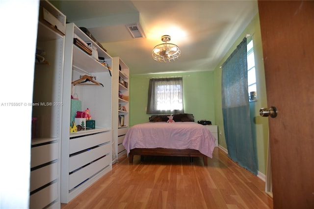 bedroom with light wood-style flooring and visible vents