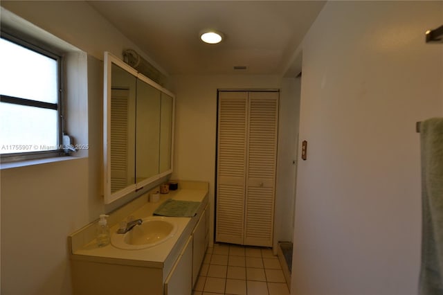 bathroom with vanity, visible vents, a closet, and tile patterned floors