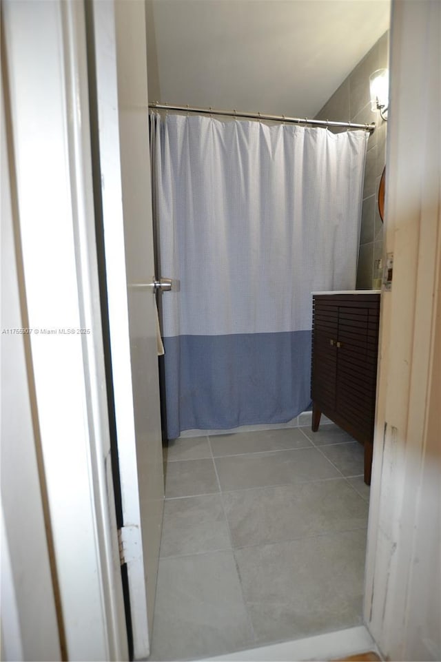 full bath featuring curtained shower and tile patterned flooring