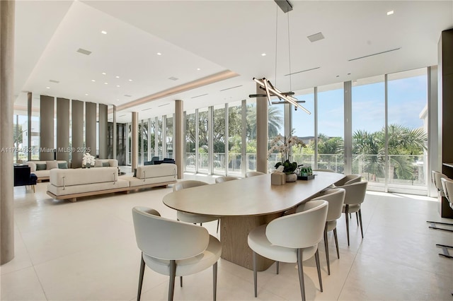 dining room featuring expansive windows, a tray ceiling, plenty of natural light, and visible vents