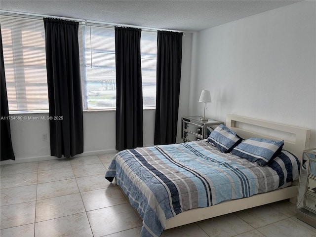 bedroom with light tile patterned flooring and a textured ceiling