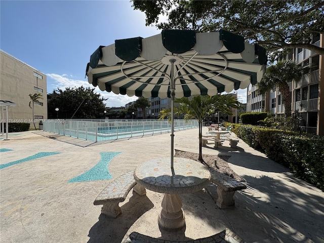 view of property's community featuring fence, a pool, and a patio