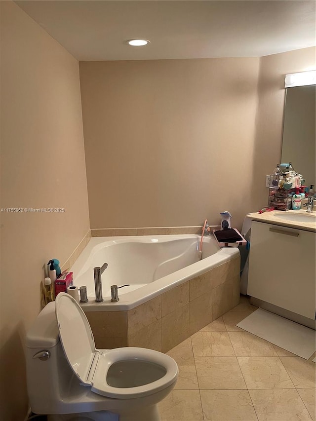 bathroom with a garden tub, vanity, and toilet