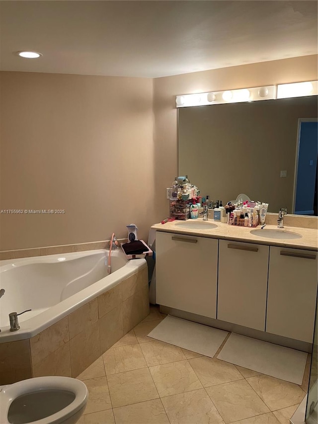 full bathroom with double vanity, a garden tub, and a sink