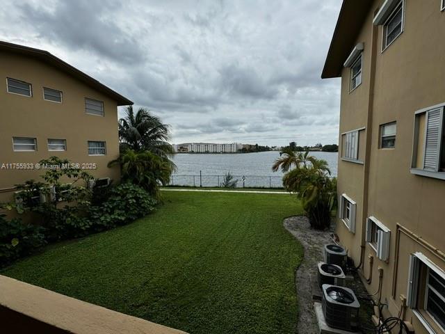 view of yard with a water view and central air condition unit