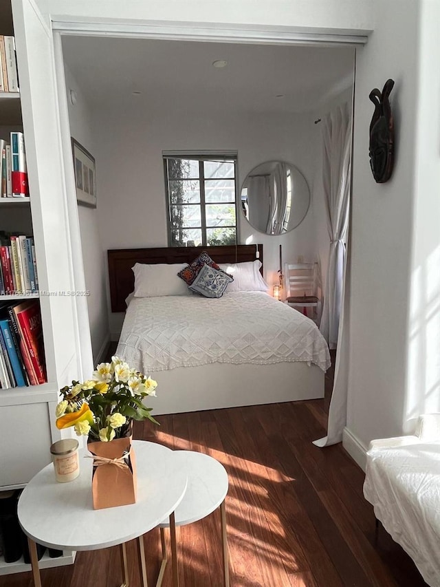 bedroom with wood finished floors and baseboards