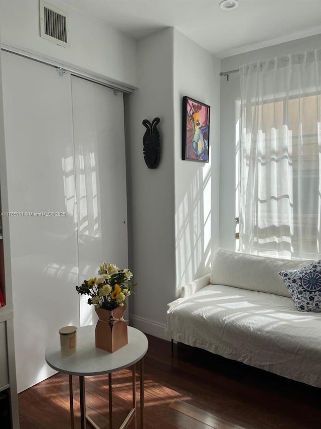 sitting room featuring baseboards, visible vents, and wood finished floors