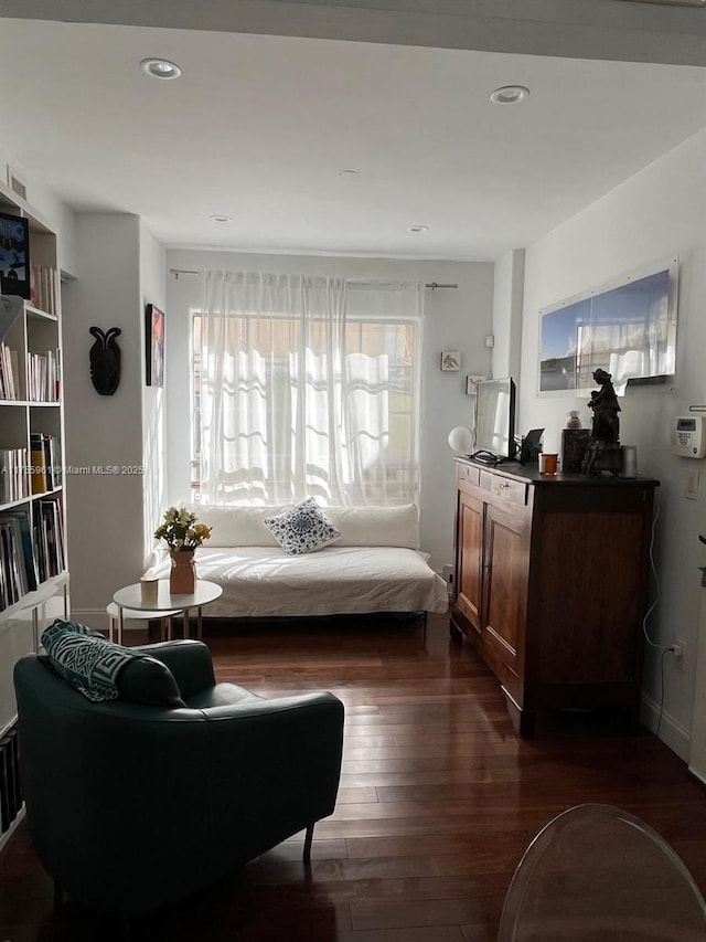 living area with dark wood-style flooring and recessed lighting