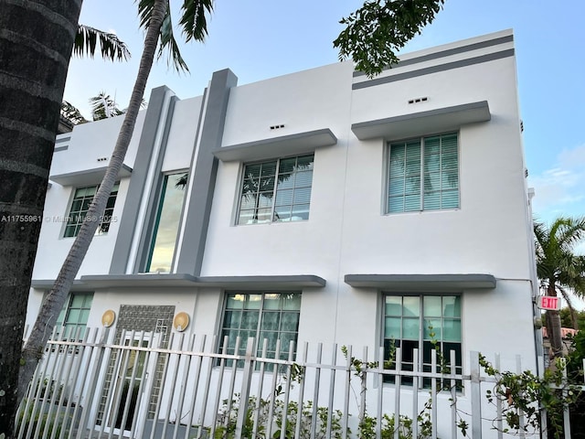 view of front of home featuring fence and stucco siding