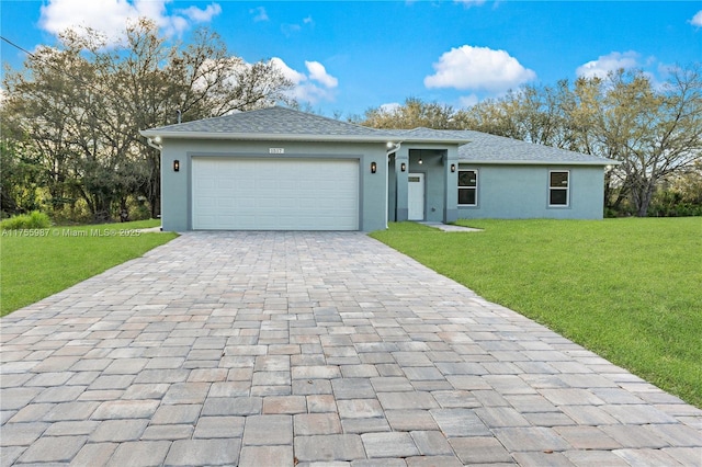 single story home featuring a garage, decorative driveway, a front lawn, and stucco siding