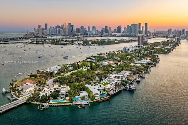 aerial view at dusk with a view of city and a water view