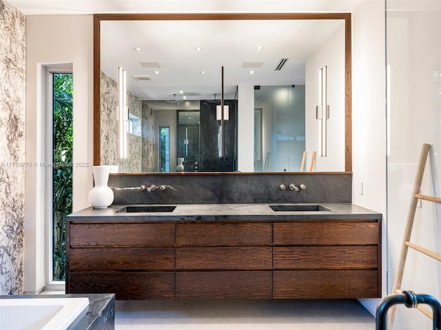 full bath featuring a sink, a stall shower, double vanity, and visible vents