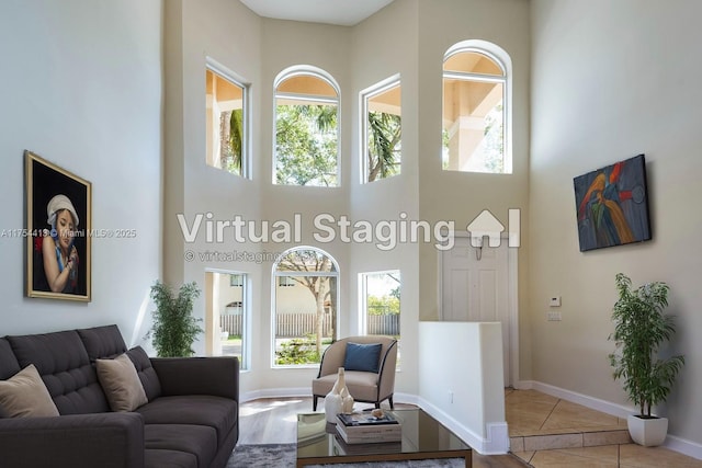 tiled living room with baseboards and a towering ceiling