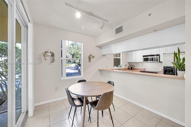 dining space featuring light tile patterned floors, baseboards, and visible vents