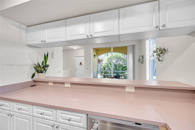 kitchen featuring dishwasher, light countertops, and white cabinets