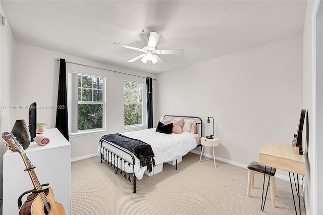 bedroom featuring light carpet, ceiling fan, and baseboards