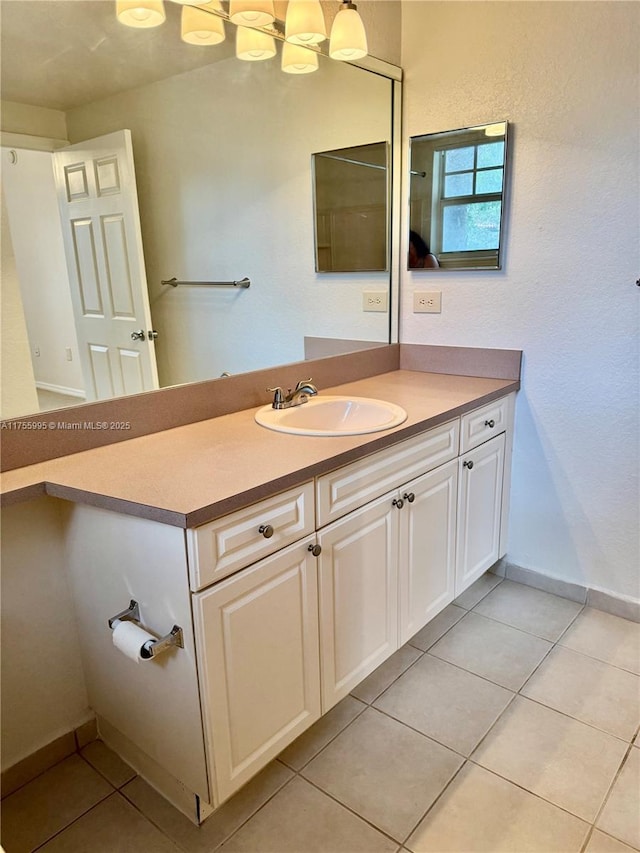 bathroom featuring tile patterned flooring, vanity, and baseboards