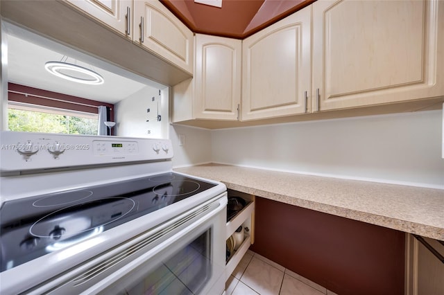 kitchen with built in desk, light countertops, electric range, and light tile patterned floors