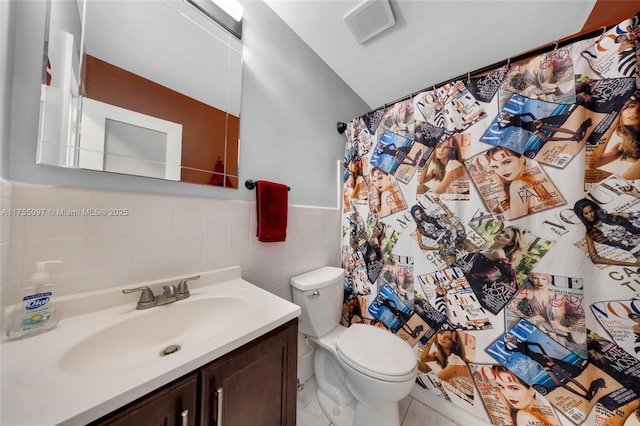 bathroom with tile walls, visible vents, toilet, wainscoting, and vanity