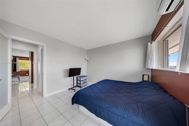 bedroom with light tile patterned floors, baseboards, and a wall mounted AC