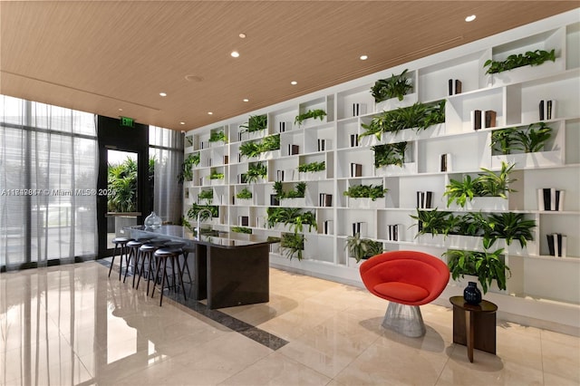 interior space with expansive windows, wooden ceiling, built in shelves, and recessed lighting