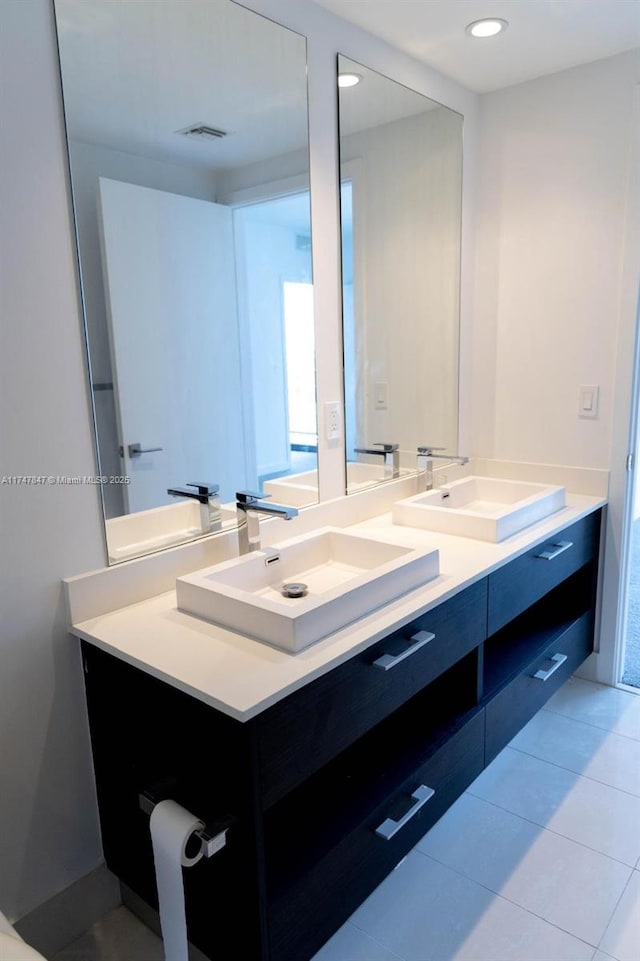 full bath with double vanity, tile patterned flooring, visible vents, and a sink