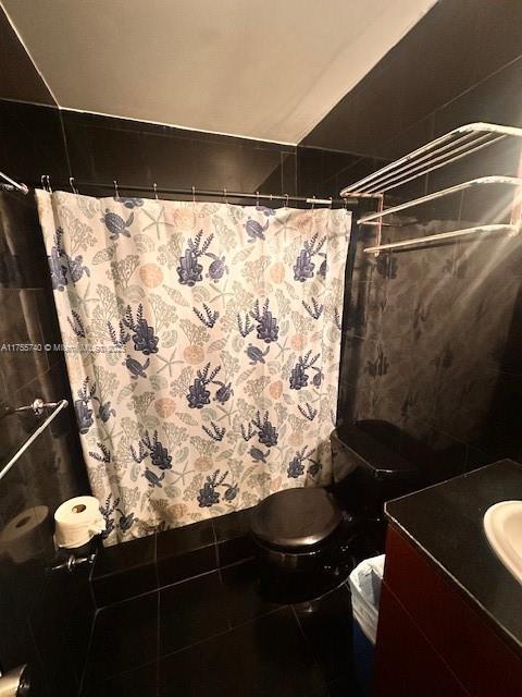 full bath featuring toilet, curtained shower, tile patterned flooring, and vanity