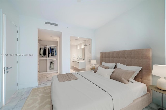 bedroom with visible vents, a walk in closet, marble finish floor, ensuite bathroom, and a closet