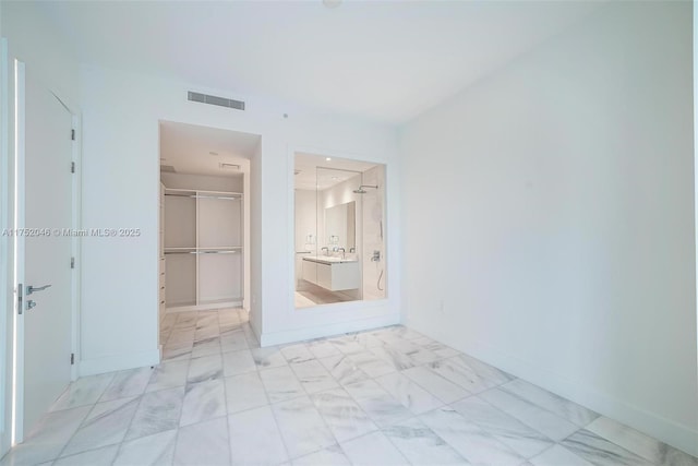 unfurnished bedroom with visible vents, a walk in closet, baseboards, a closet, and marble finish floor