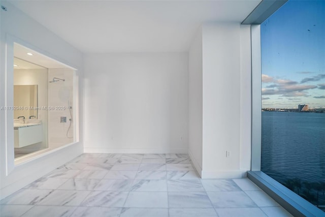 interior space with vanity, baseboards, and marble finish floor