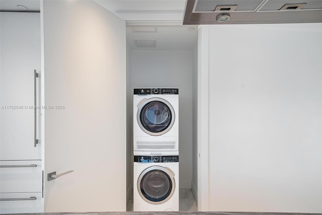 clothes washing area with laundry area, stacked washer / dryer, attic access, and visible vents