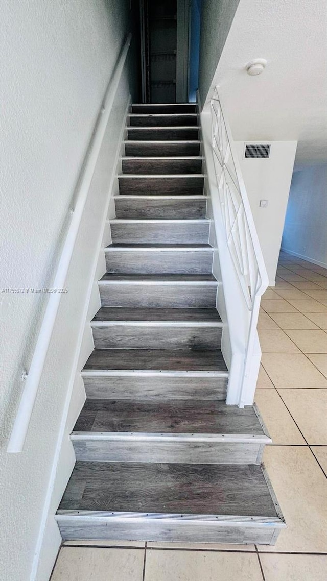 stairs with tile patterned flooring