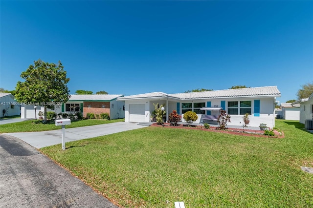 single story home featuring a front yard, concrete driveway, central AC, and an attached garage