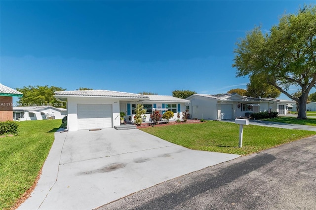 ranch-style house featuring driveway, an attached garage, and a front yard