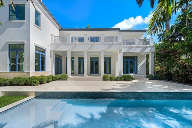 back of property featuring a balcony, stucco siding, a patio, and french doors