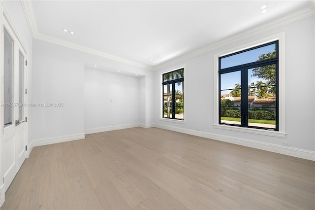 empty room with light wood-type flooring, baseboards, and ornamental molding