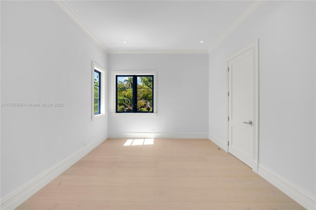 spare room with light wood-style floors, baseboards, and crown molding