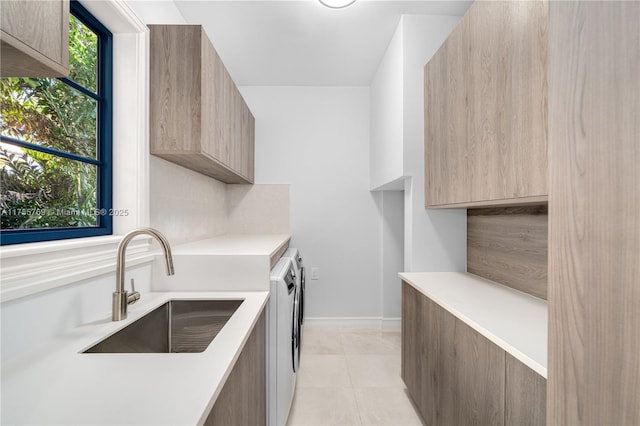 kitchen featuring a sink, light countertops, independent washer and dryer, tasteful backsplash, and modern cabinets