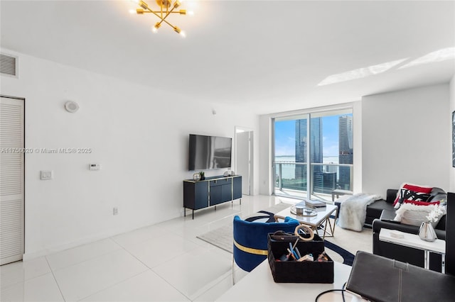 tiled living area featuring expansive windows and a chandelier