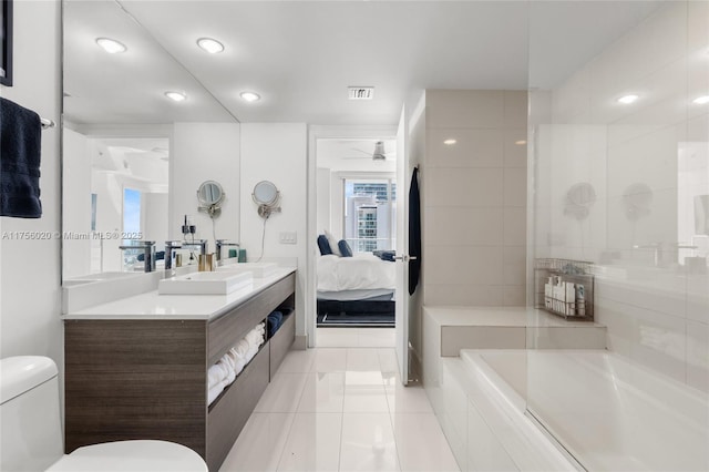 ensuite bathroom with tile patterned flooring, toilet, vanity, visible vents, and ensuite bath