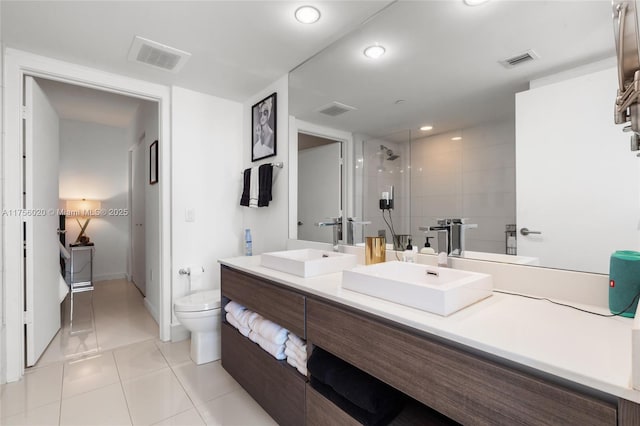 full bathroom with tile patterned floors, visible vents, a sink, and a walk in shower