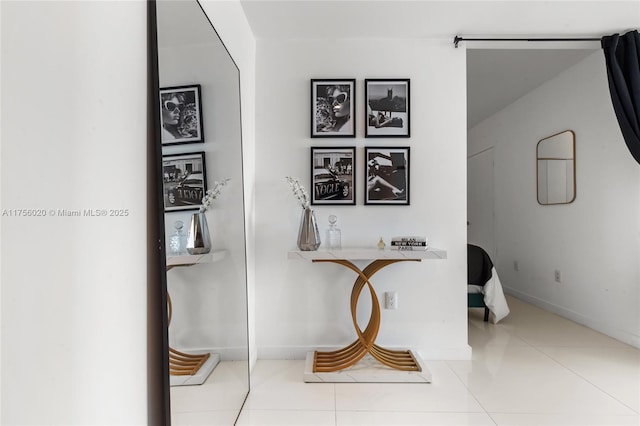 hallway featuring tile patterned flooring and baseboards