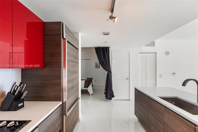 kitchen with light tile patterned floors, light countertops, a sink, and visible vents