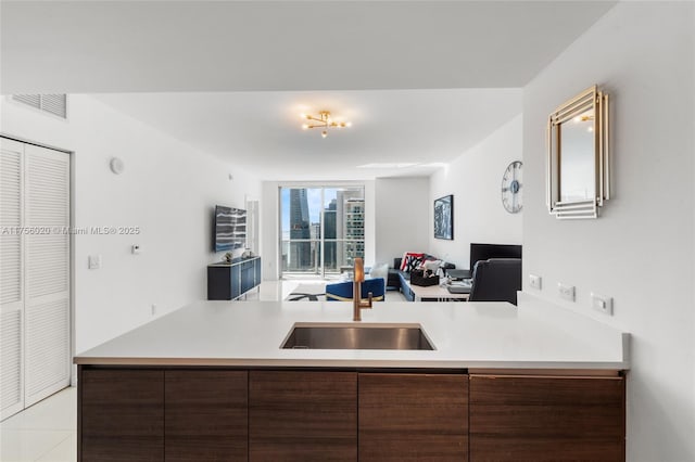 kitchen featuring a sink, visible vents, open floor plan, light countertops, and modern cabinets