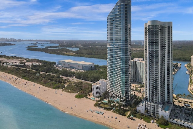 bird's eye view with a water view, a view of the beach, and a city view