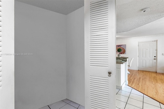 hallway with light tile patterned flooring and a textured ceiling