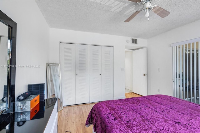 bedroom featuring a textured ceiling, a closet, light wood-type flooring, and visible vents