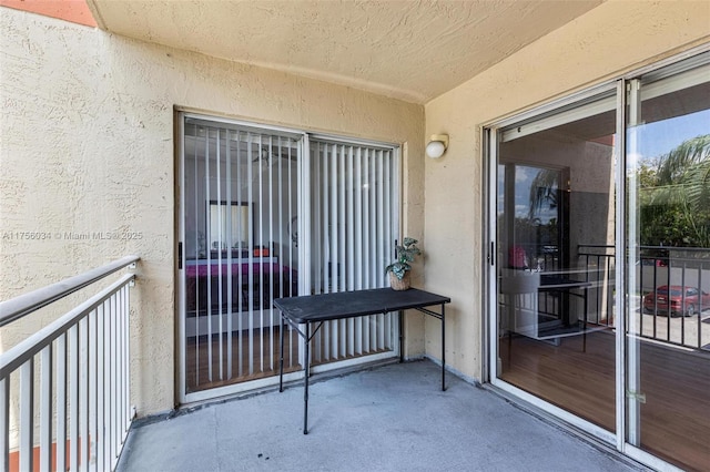 doorway to property with a balcony and stucco siding