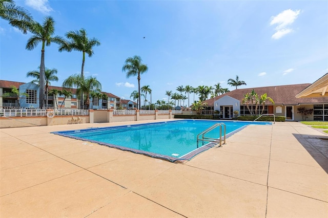 community pool featuring a patio and fence